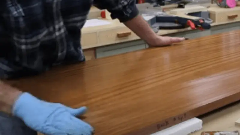 Polishing polyurethane on wood in forward and backward strokes 