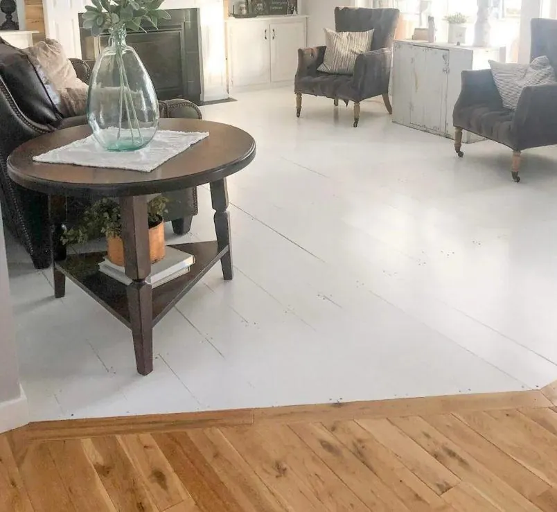 whitewashed painted wide plank pine floor farmhouse living room with wood accent wall and fireplace