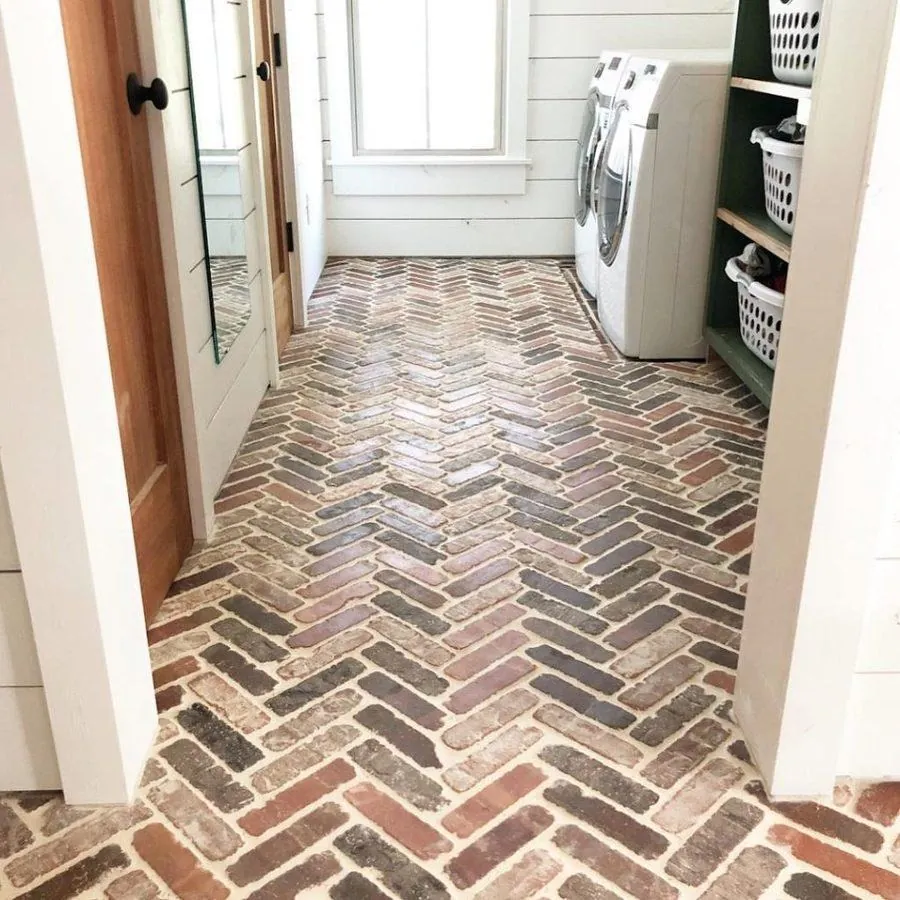close-up reclaimed brick herringbone farmhouse mudroom floor with shiplap walls and glass doors