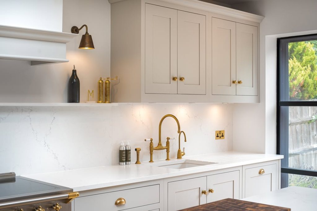  soft white shaker cabinets with elegant brass accents.